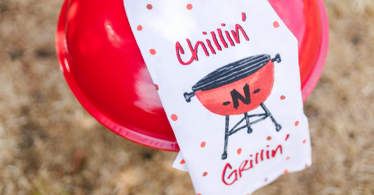 close up of a red grill and themed towel in a sunny outdoor setting