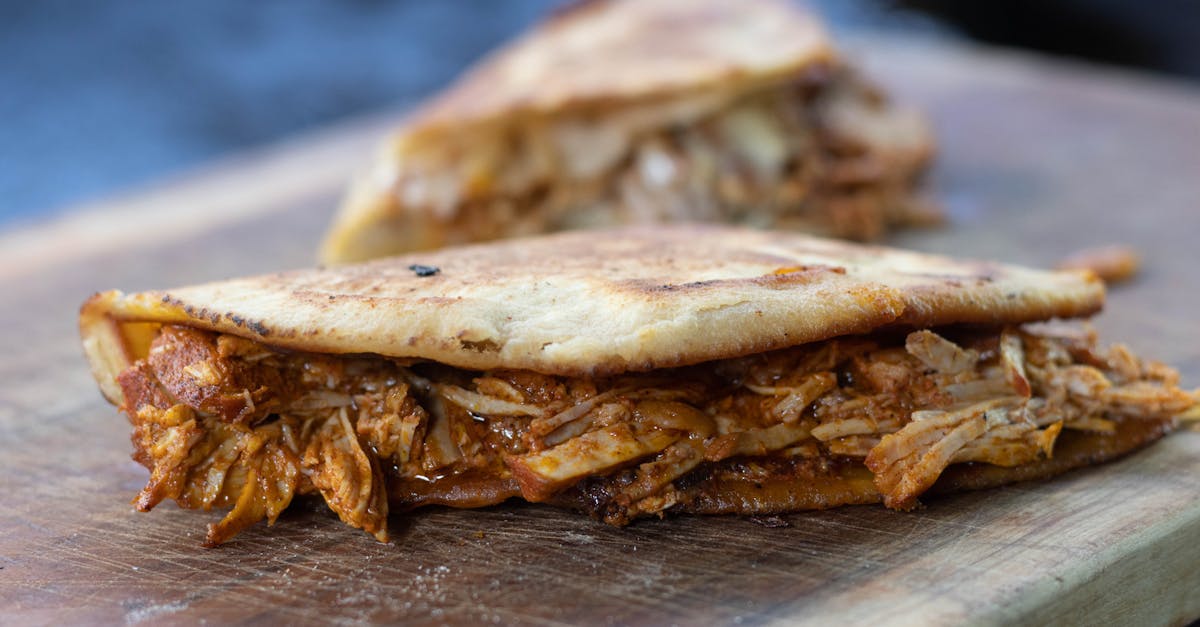 close up of a savory arepa filled with juicy pulled pork on a wooden board 5