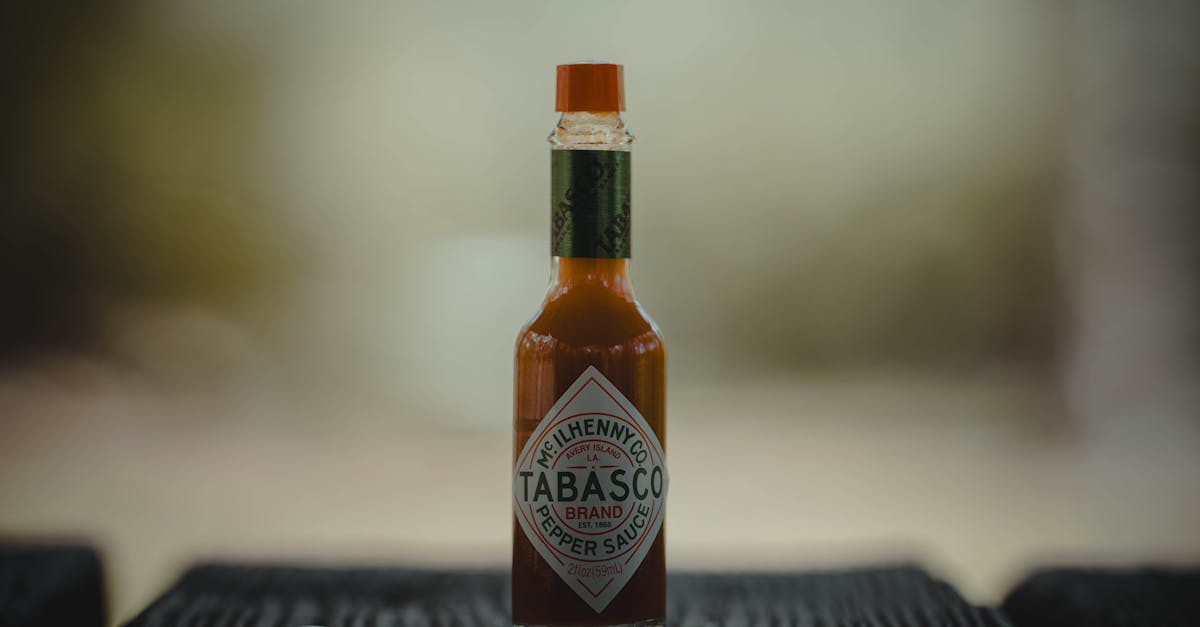 close up of a tabasco sauce bottle on a wooden surface emphasizing its spicy essence