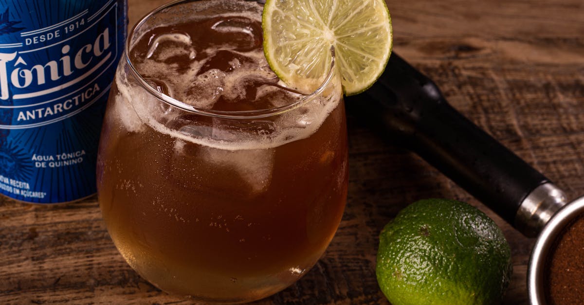 close up of a tonic cocktail garnished with a lime slice on a rustic wooden table