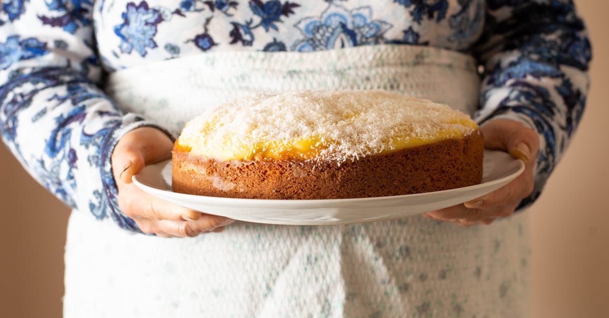 close up of a woman holding a delicious homemade coconut cake on a white plate 2