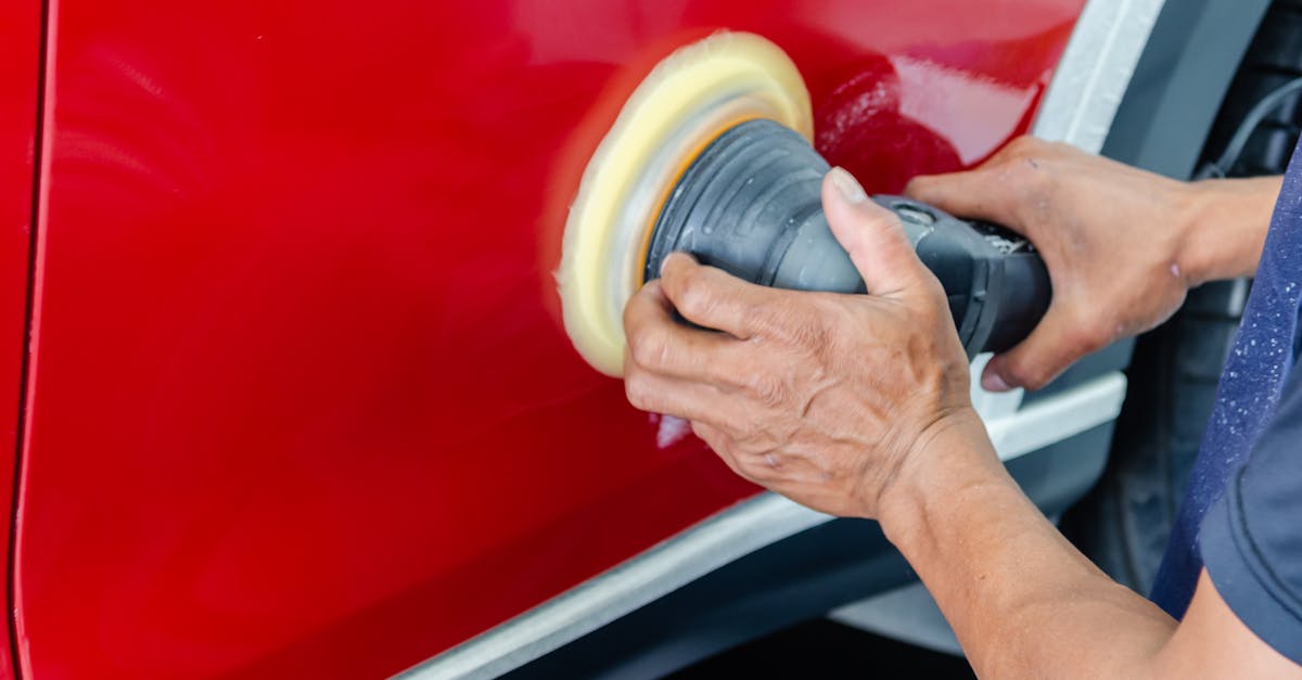 close up of a worker buffing red car paint for shine and maintenance 1