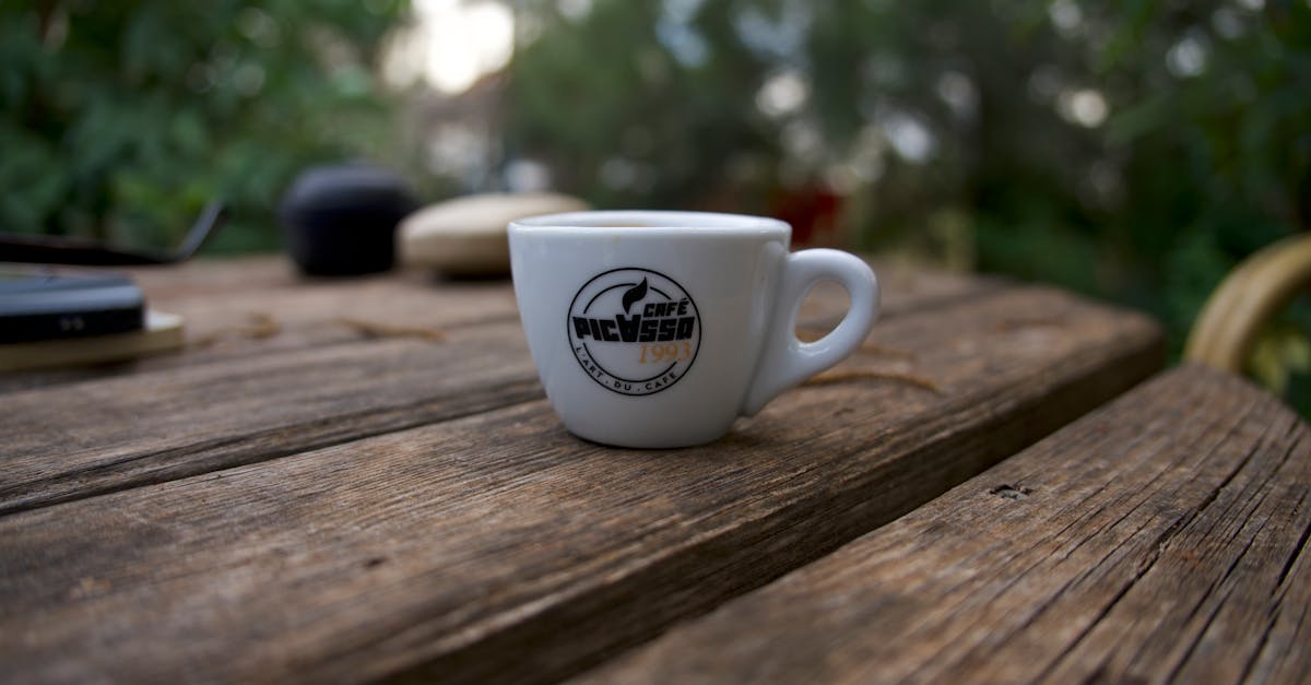 close up of an espresso cup on a rustic wooden table surrounded by a natural setting