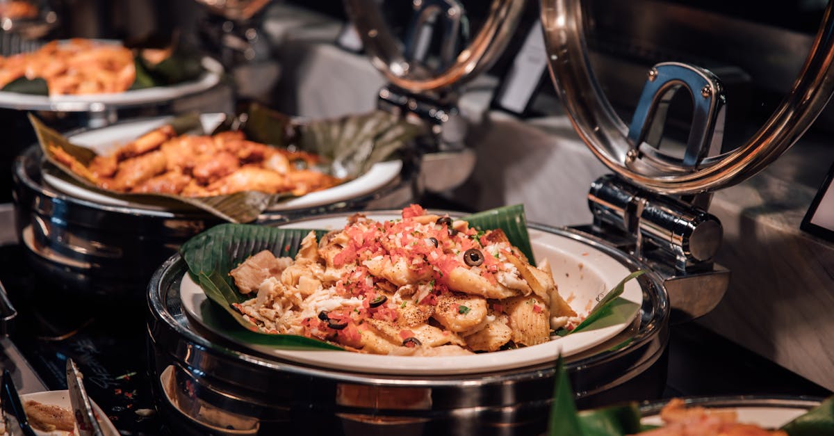 Home close up of appetizing pasta dishes at an elegant buffet with warm lighting and garnishes