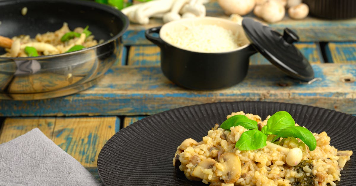 close up of creamy mushroom risotto with rice and basil styled on a rustic wooden table 2