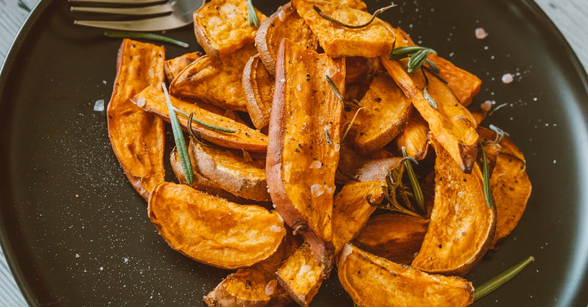 close up of crispy sweet potato wedges topped with rosemary perfect for a healthy snack