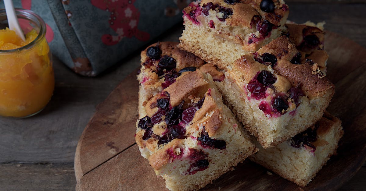 Home close up of delicious homemade berry cake slices with jam on a wooden board 1