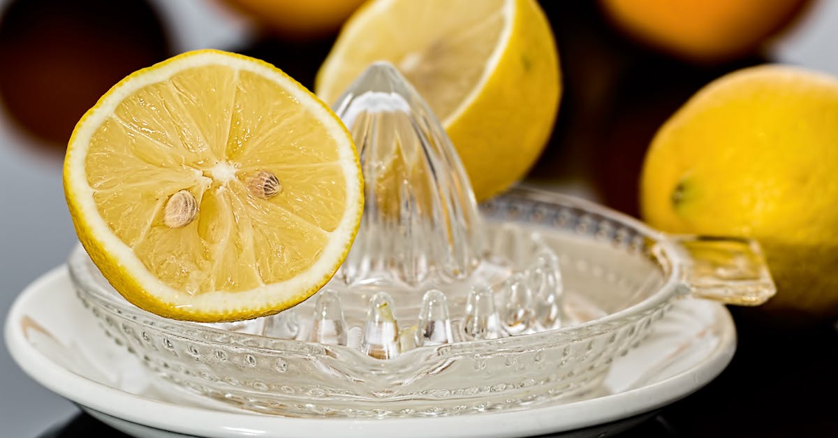 close up of fresh lemons on a glass juicer ready to make citrus refreshment