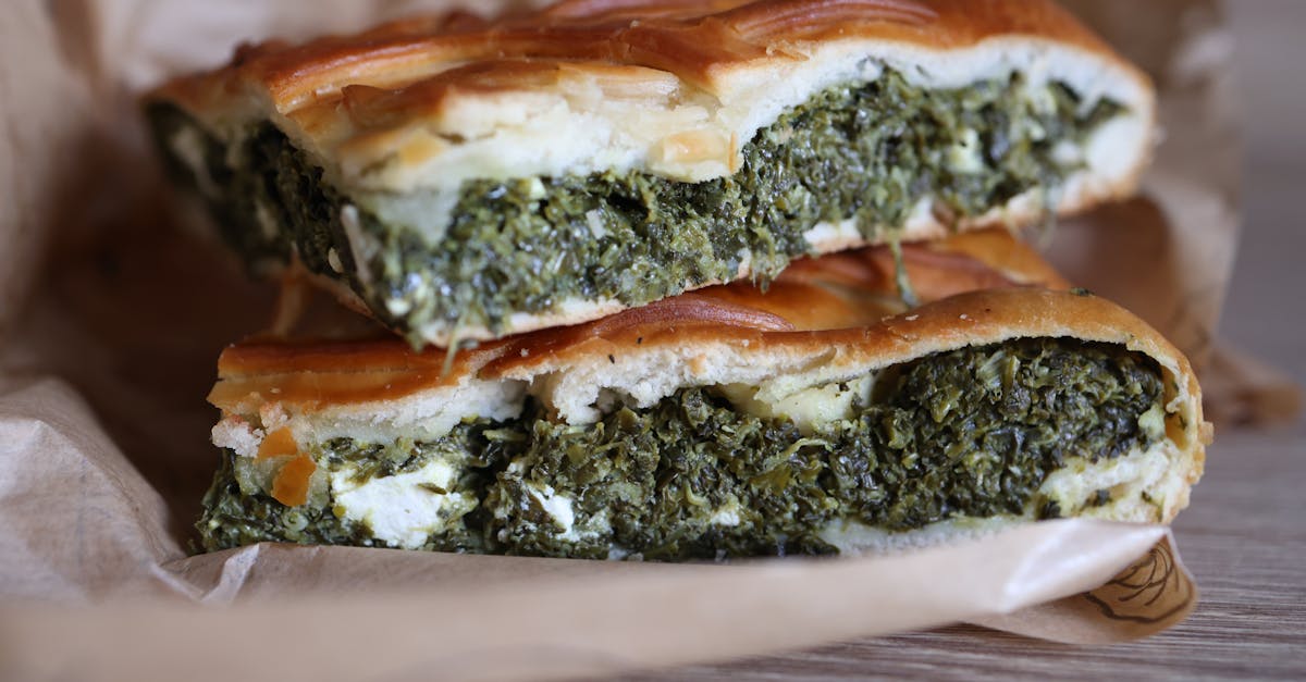 close up of fresh spinach and feta spanakopita slices on parchment paper 2