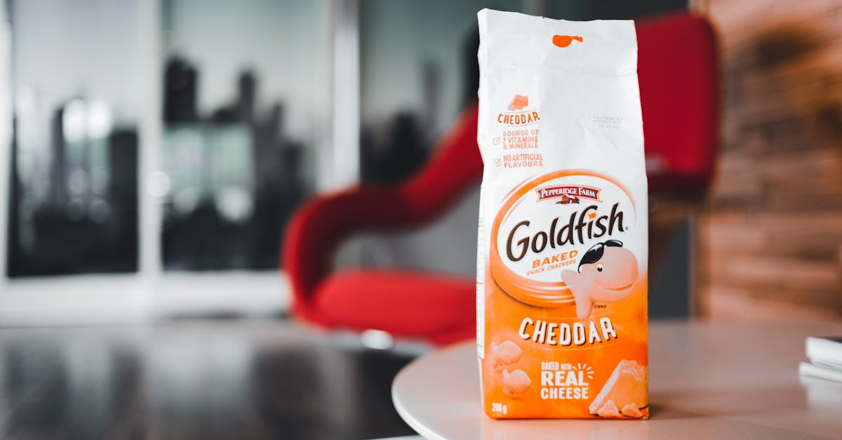 close up of goldfish cheddar crackers pack on a table with red chair backdrop
