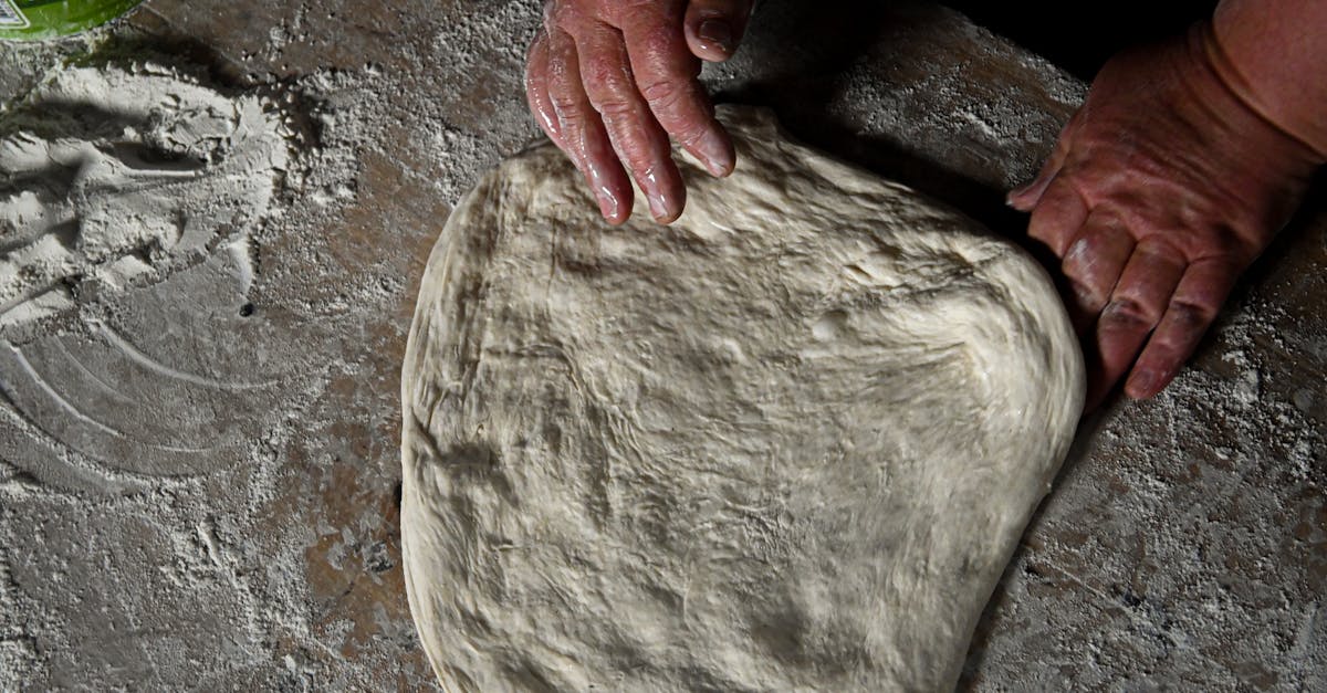 Home close up of hands kneading dough on a floured surface showcasing homemade baking