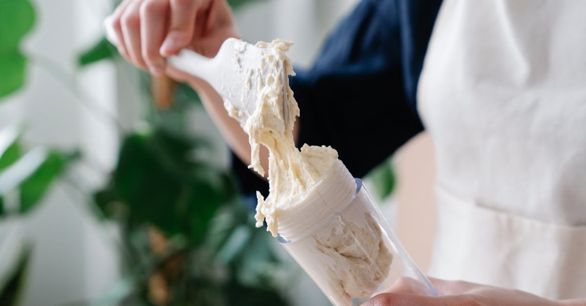 close up of hands transferring fresh cream into an icing syringe perfect for food photography enthu 1