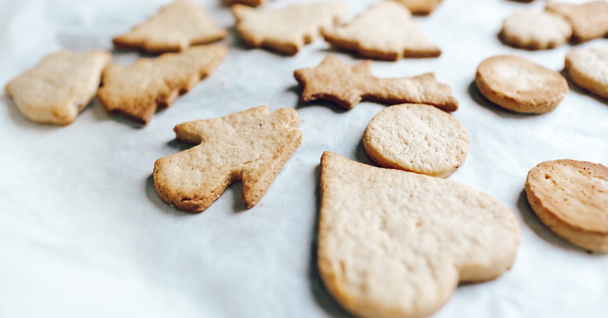 close up of homemade christmas cookies with festive shapes on a parchment lined baking sheet 4