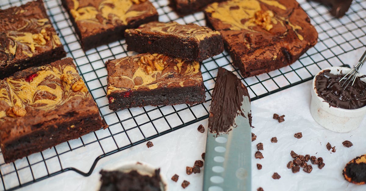 close up of rich chocolate brownies with nuts and marbled design sliced on a cooling rack