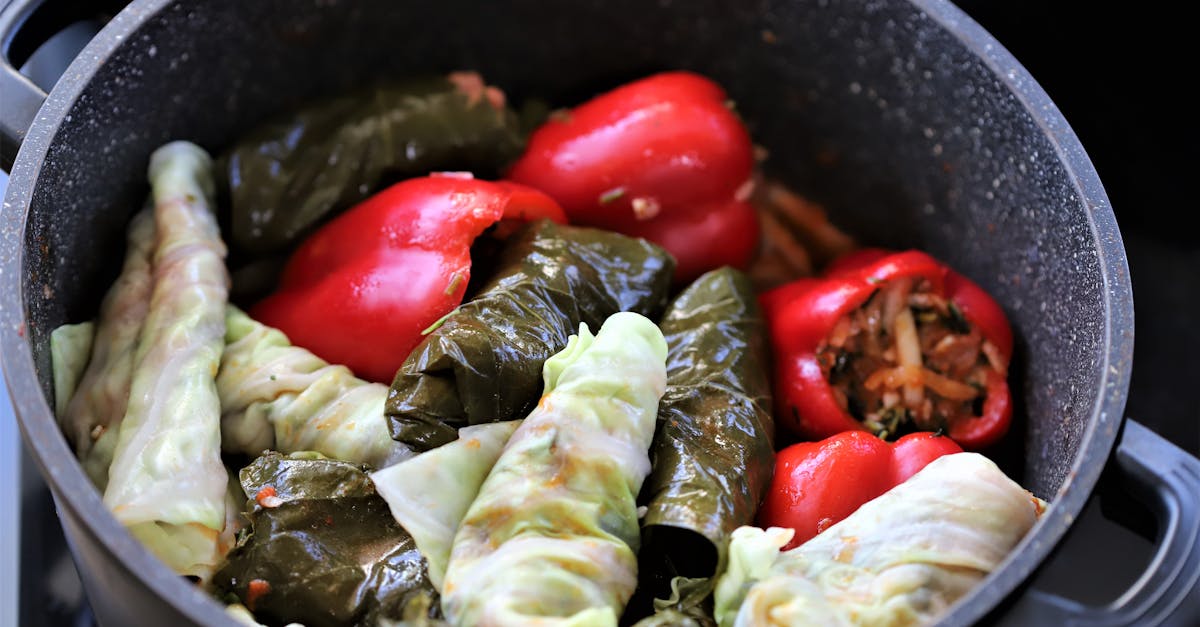 close up of stuffed peppers and cabbage leaves cooking in a pot a vibrant and appetizing display