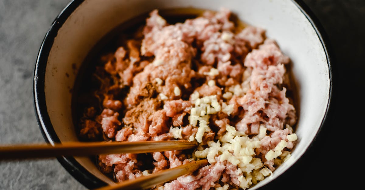 close up of uncooked minced pork and chopped garlic in a bowl emphasized texture 1