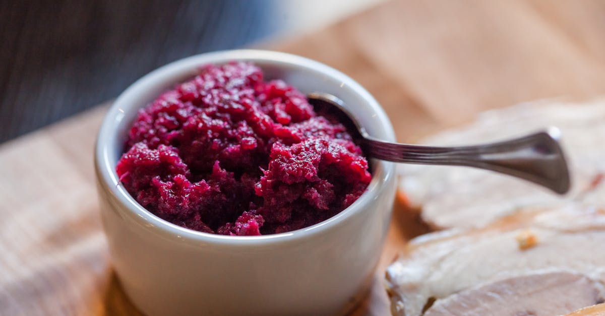 close up of vibrant cranberry sauce in a bowl with a spoon perfect for holiday meals 3