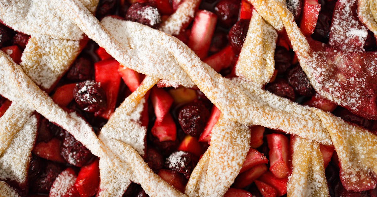 close up photo of a cherry and apple pie with a lattice crust dusted in powdered sugar