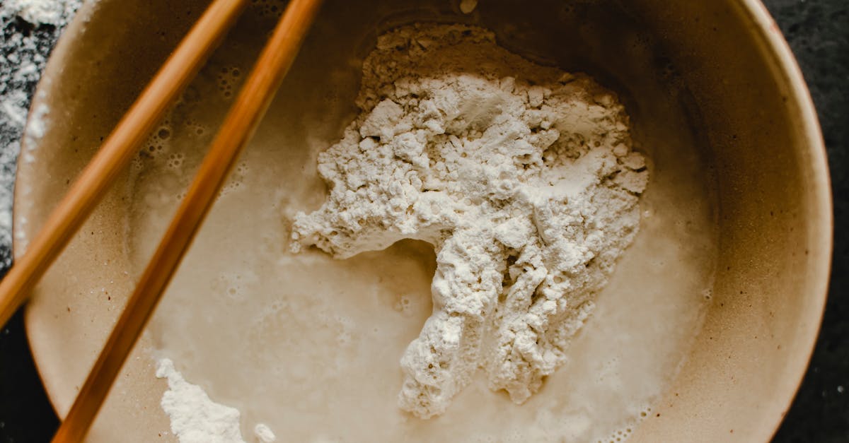 close up view of flour mixed with water using chopsticks highlighting food preparation