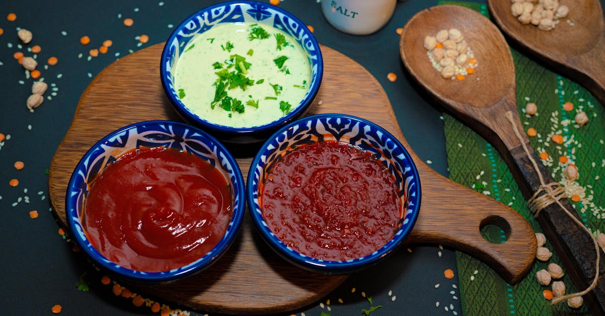 colorful assortment of sauces in blue ceramic bowls on a wooden board perfect for snacks