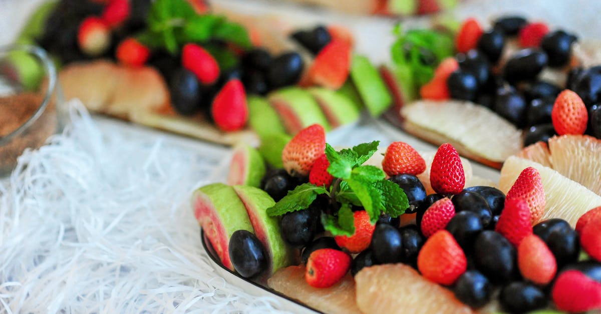 colorful platter featuring fresh strawberries grapes and guava with a touch of mint garnish