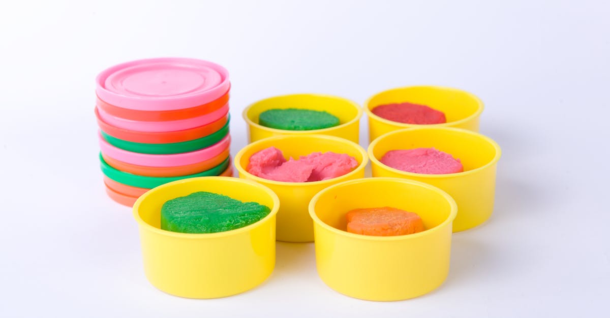 colorful playdough in yellow containers with stacked pastel lids on white background 2