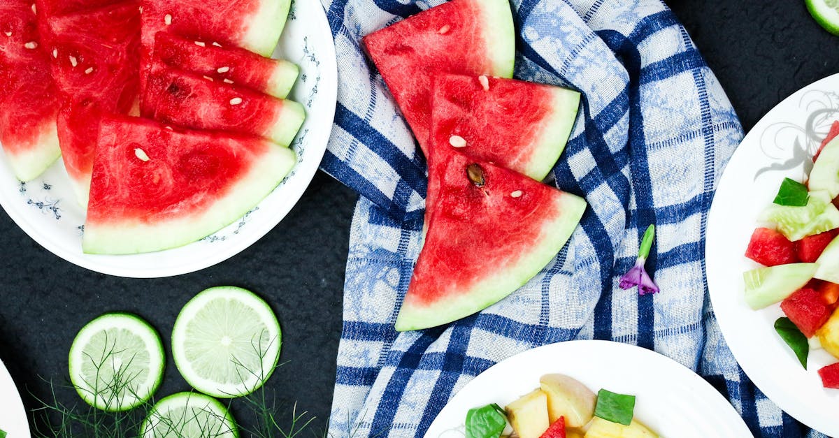 colorful top view of watermelon and lime slices on plates with fresh salad