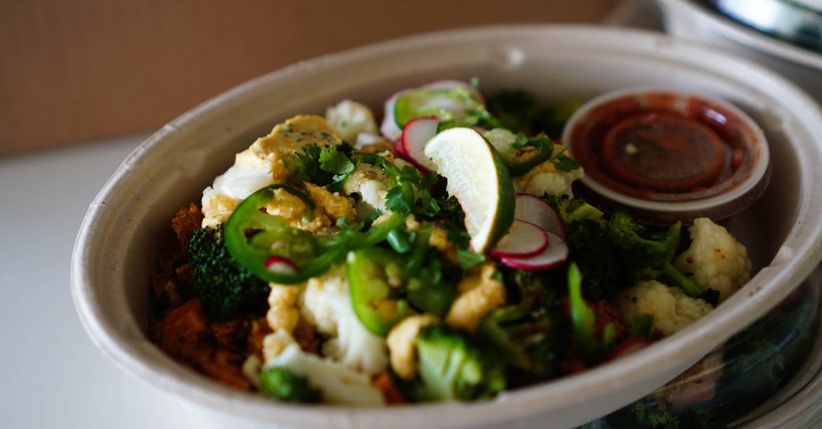 colorful vegetable salad bowl with broccoli cauliflower jalapeno and lime in eco friendly packagi