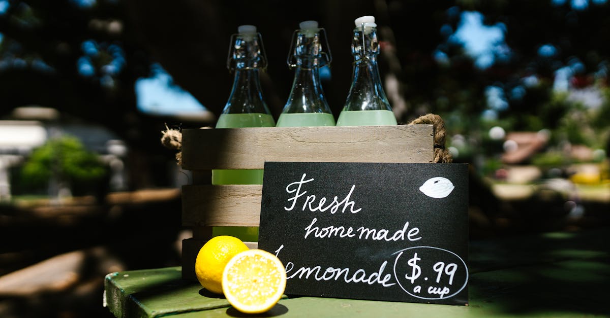 crate of glass bottles with lemonade on outdoor table priced at 0 99 a cup 3