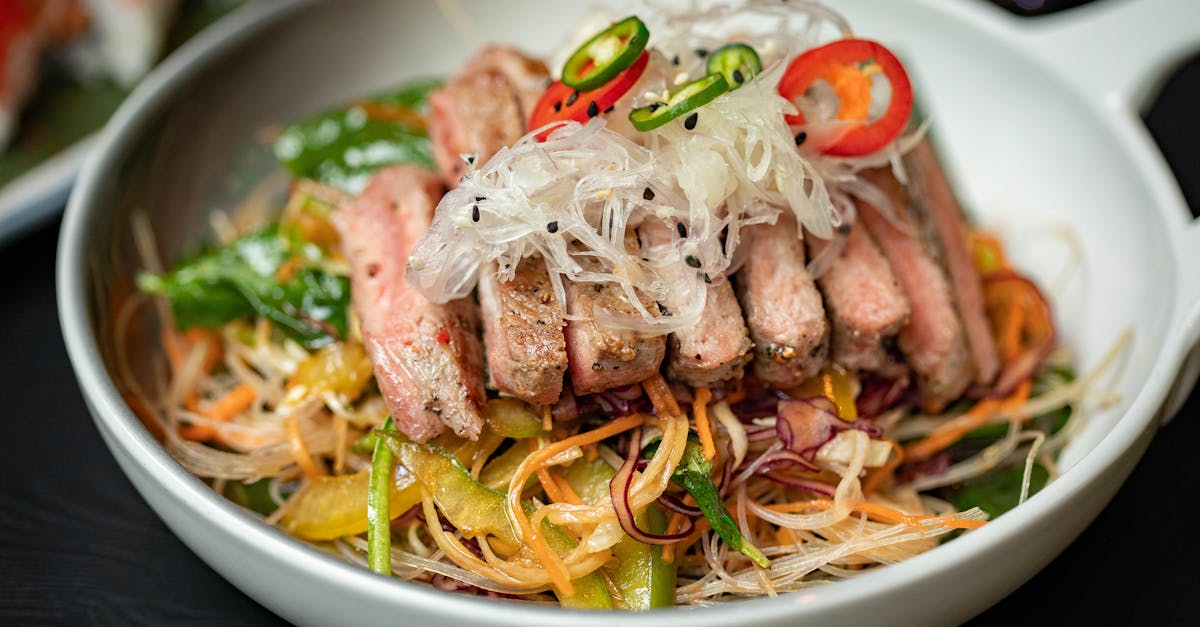 delicious asian noodle salad topped with sliced meat peppers and fresh garnishes 2