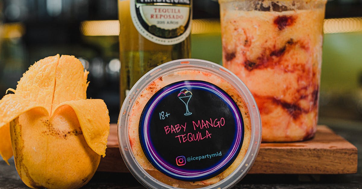 delicious baby mango tequila sorbet in a container with a tequila bottle and mango peel 1