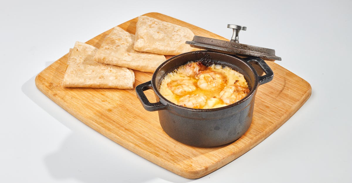 delicious cheesy shrimp dip served in a mini pot with tortilla wedges on a wooden cutting board 4