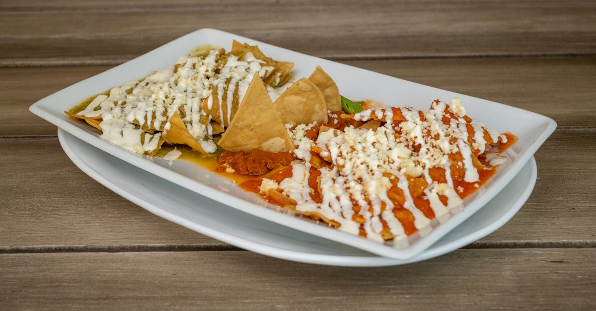 delicious chilaquiles platter with red and green salsa garnished with cheese and cream served on a