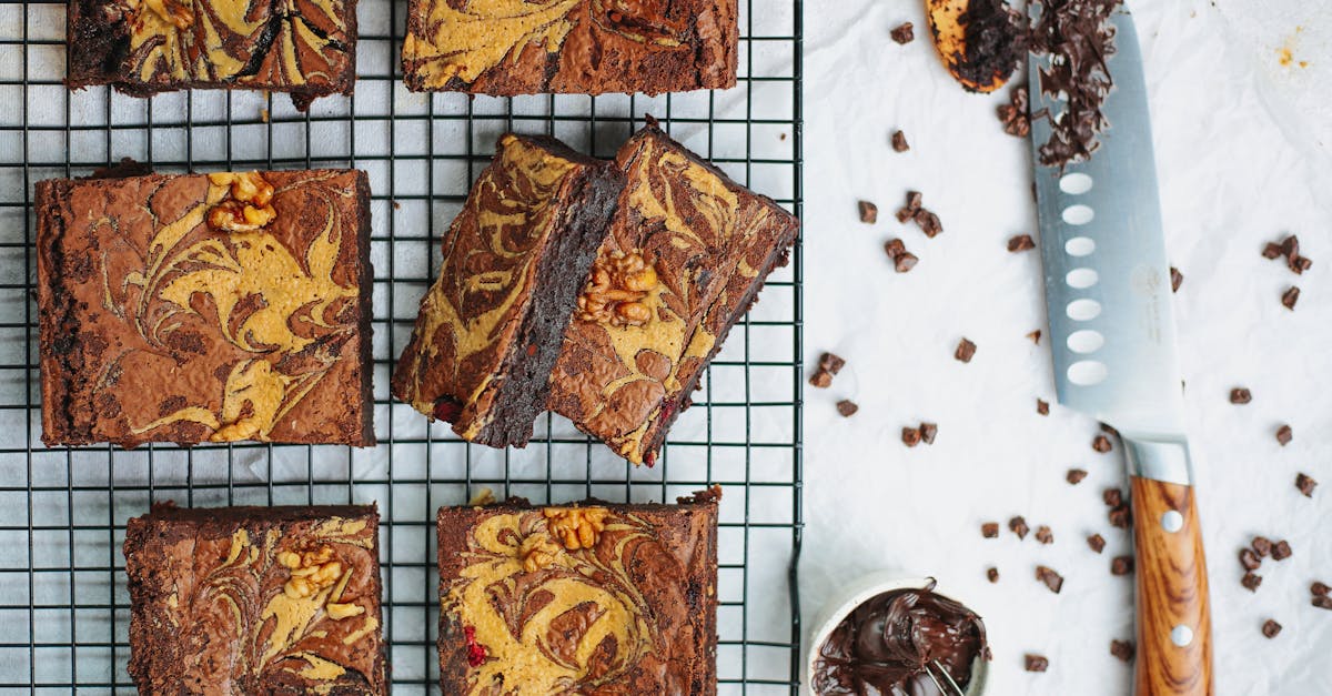 delicious chocolate brownies with walnuts on a cooling rack and knife on white background