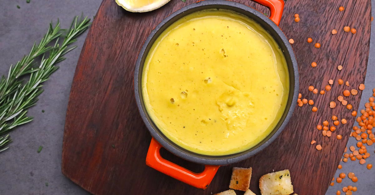 delicious creamy lentil soup garnished with fresh herbs served with croutons and a slice of lemon