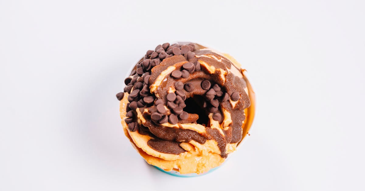 delicious donut topped with chocolate chips and peanut butter glaze on white background
