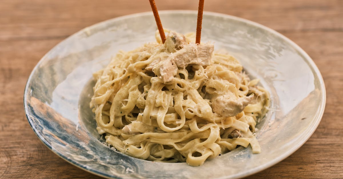 delicious fettuccine alfredo with chicken on a rustic wooden table