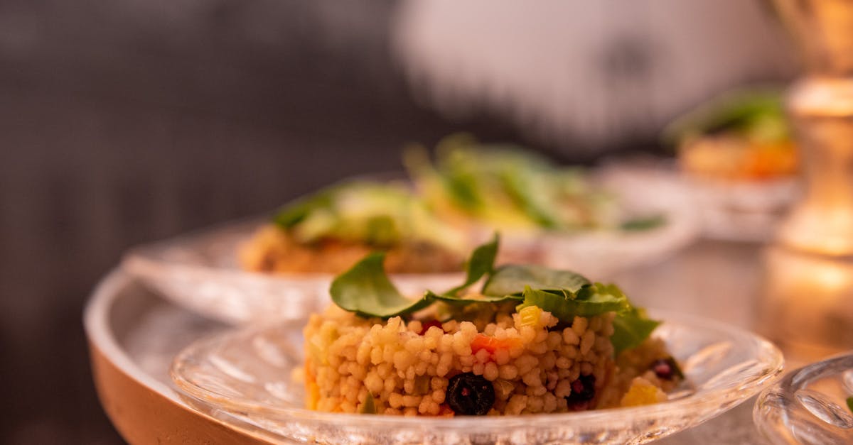 delicious fregola pasta on a clear glass plate garnished with greens