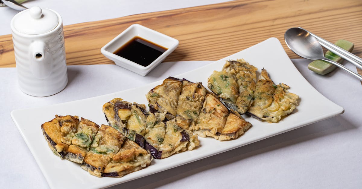 delicious fried eggplant slices served with soy sauce on a white plate 1