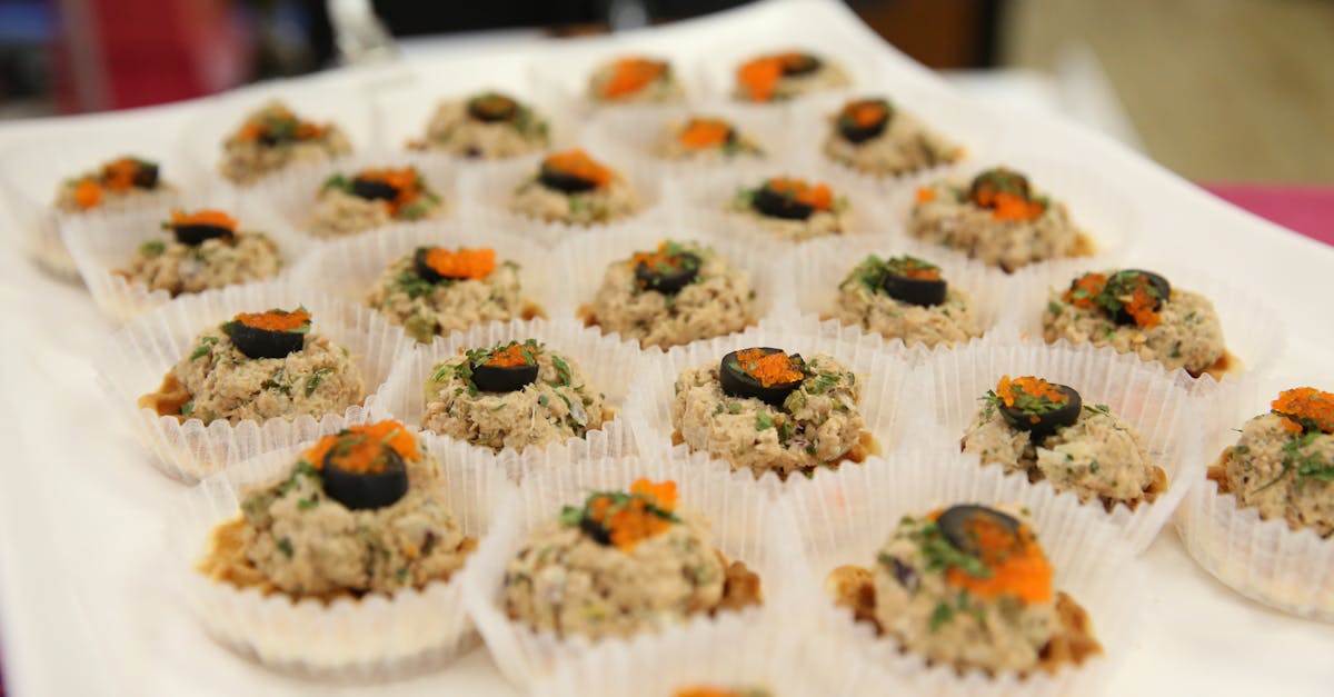 delicious gourmet appetizers topped with olives and herbs on display in a catering setup