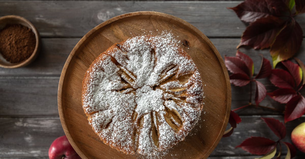delicious homemade apple cake topped with powdered sugar on a wooden plate