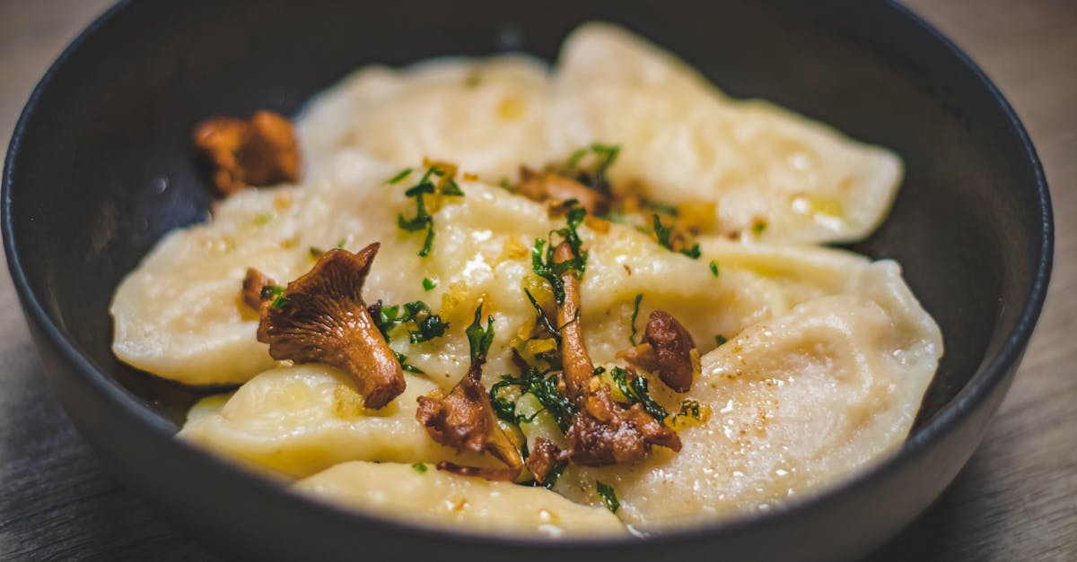 delicious homemade dumplings topped with chanterelle mushrooms and herbs in a bowl