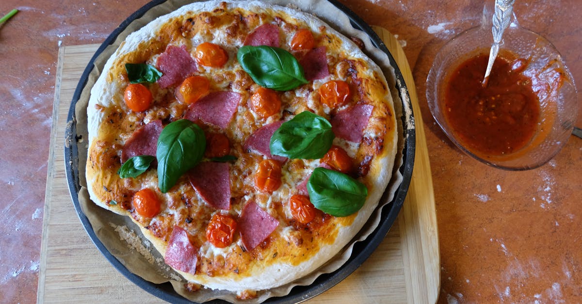 delicious homemade pizza topped with salami cherry tomatoes and basil leaves freshly baked