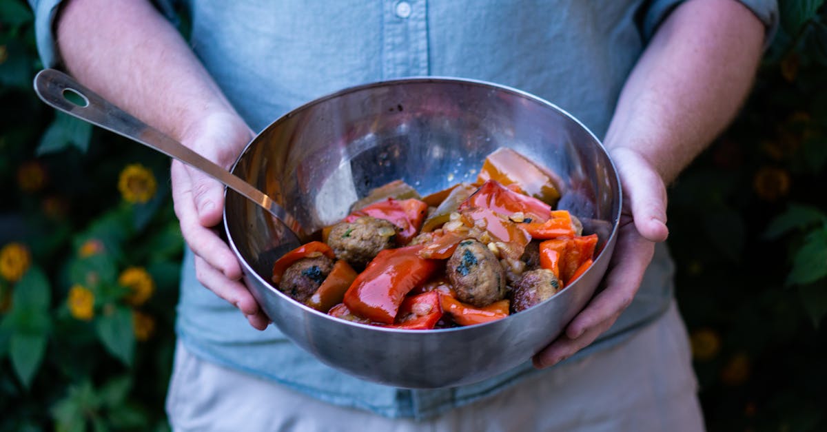 delicious homemade ratatouille and meatballs served in a large bowl held outdoors against a natural