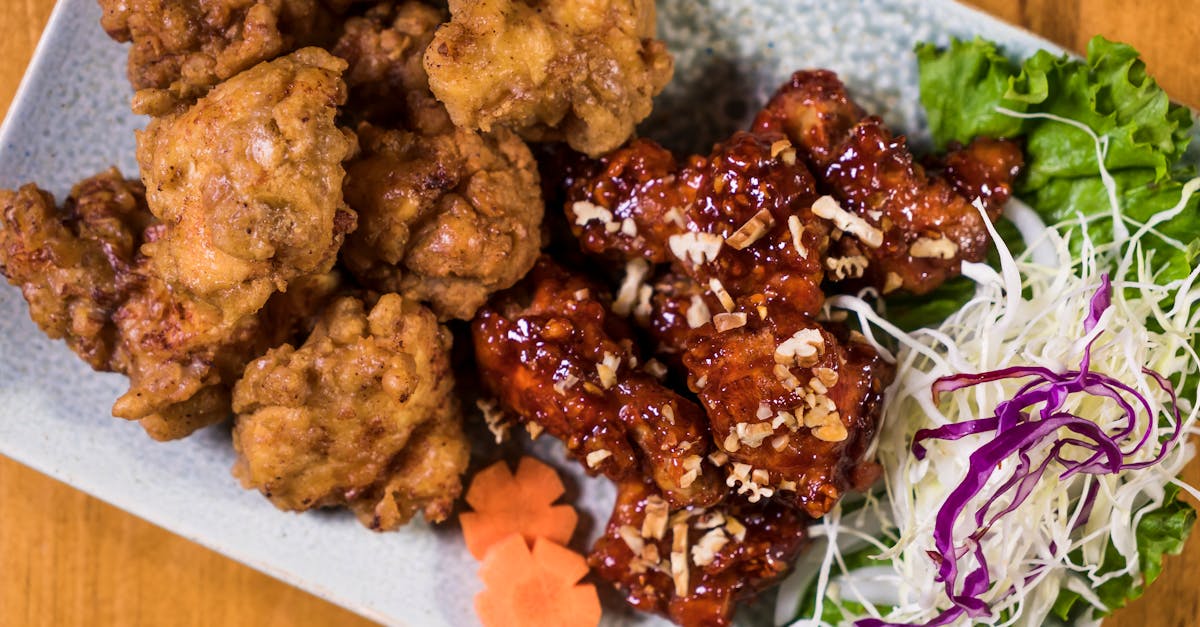 delicious korean fried chicken served with fresh salad and garnishes on a ceramic plate 8