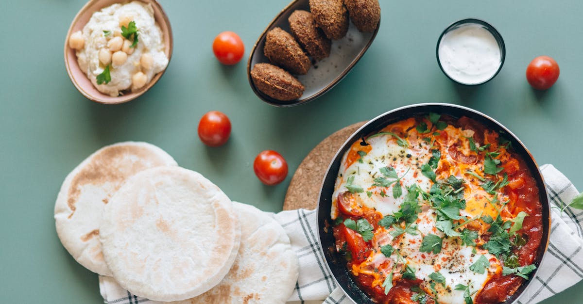 delicious middle eastern breakfast with shakshuka falafel hummus and pita bread on a table
