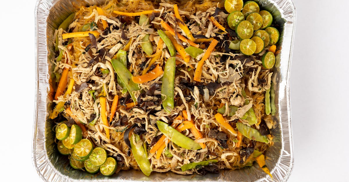 delicious pancit bihon with vegetables and calamansi in an aluminum tray top view 1