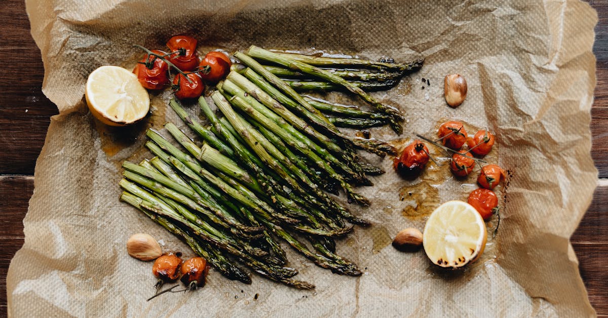delicious roasted asparagus with cherry tomatoes and lemon on parchment paper perfect for a healthy