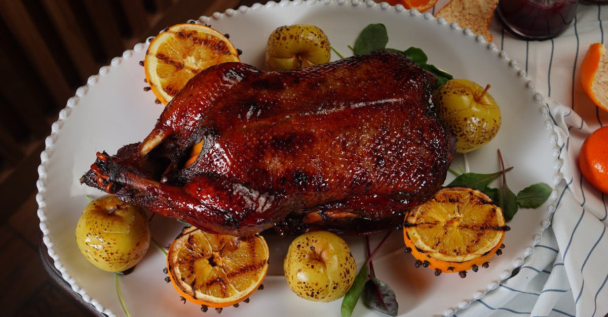 Home delicious roasted duck surrounded by grilled apples and oranges on a platter
