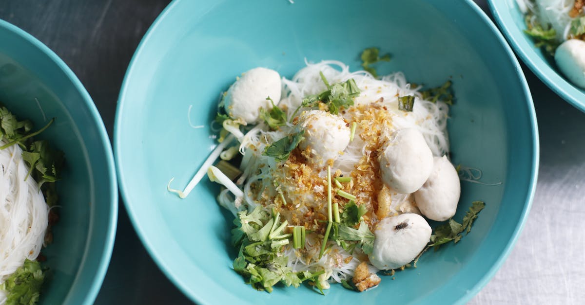 delicious traditional thai noodle soup with herbs served in vibrant blue bowls captured in thailand